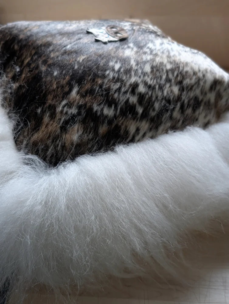 The moo cushion is a plush black and white speckled cowhide pillow with soft long wool white faux fur trim perfect for angus oliver fans
