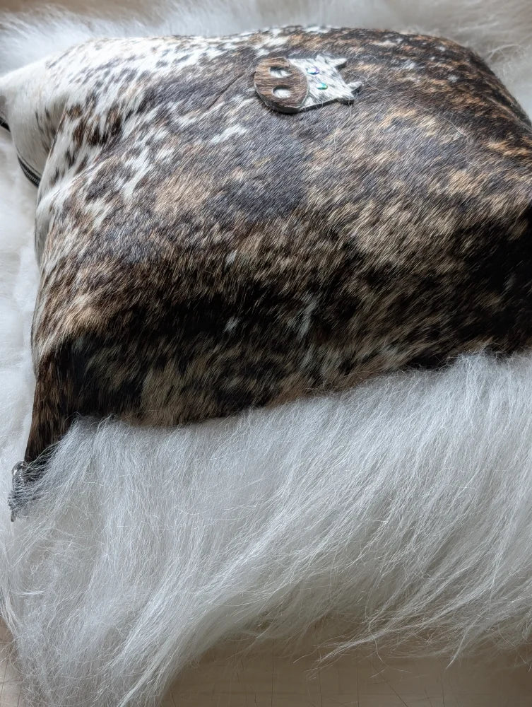 The moo cushion brown and white cowhide pillow with a silver skull brooch perfect for angus oliver and long wool fans