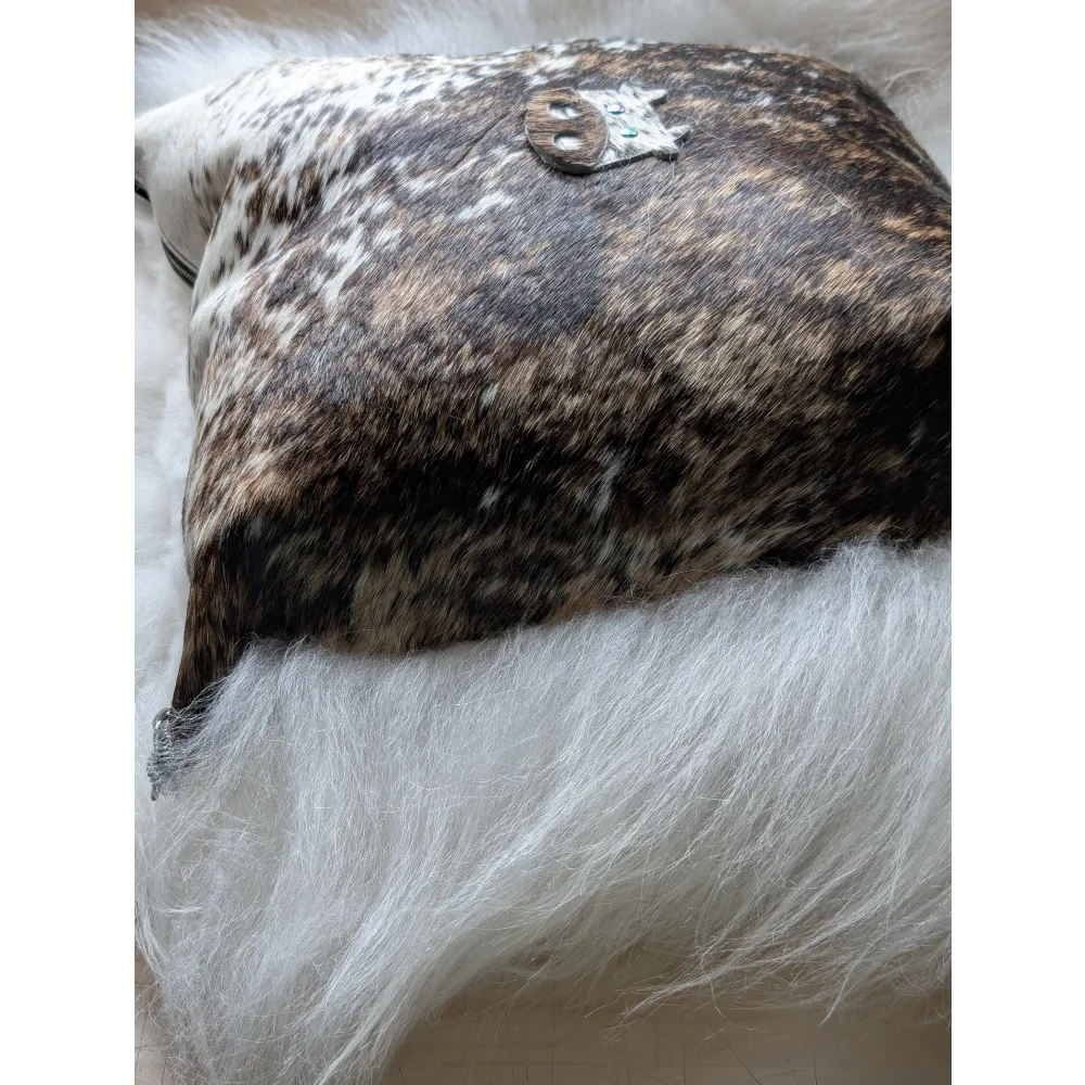 The moo cushion brown and white cowhide pillow with a silver skull brooch perfect for angus oliver and long wool fans