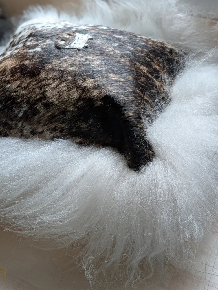 The moo cushion plush white long wool hat with dark speckled leather top and silver emblem by angus oliver