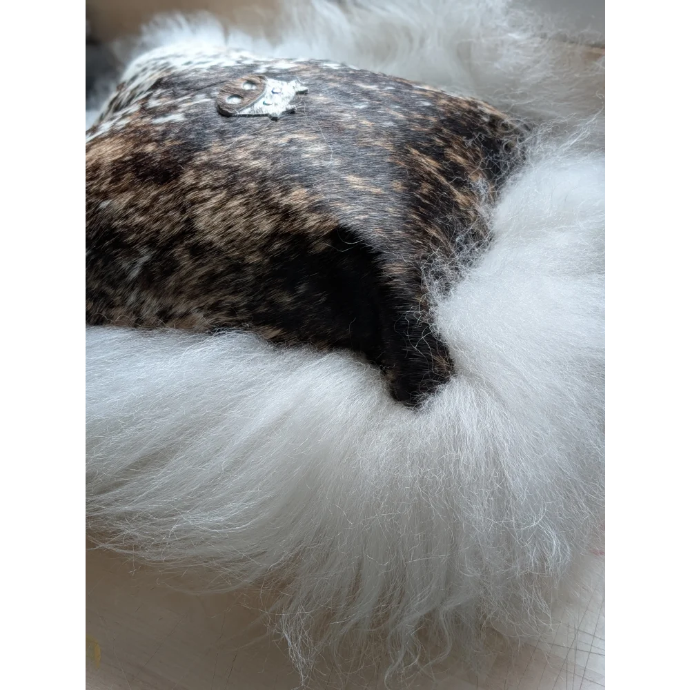 The moo cushion plush white long wool hat with dark speckled leather top and silver emblem by angus oliver