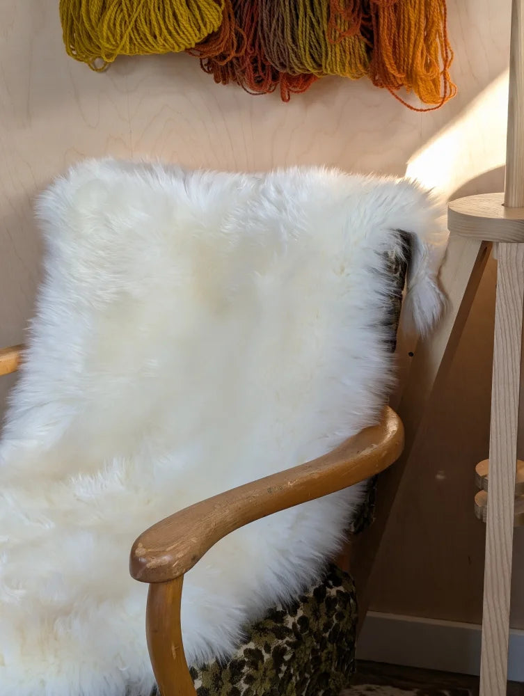 White fluffy Merino sheepskin throw on chair arm, OEKO TEX certified