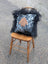 Black and white spotted yeti cushion with tan hand patch framed by black long wool icelandic sheepskin detail