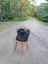 A plush natural black icelandic sheepskin fur throw with long wool draped over a rustic wooden chair perfect for cozying up