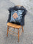 The yeti cushion cowhide icelandic sheepskin pillow with black white spots and tan hand patch framed by long wool fur