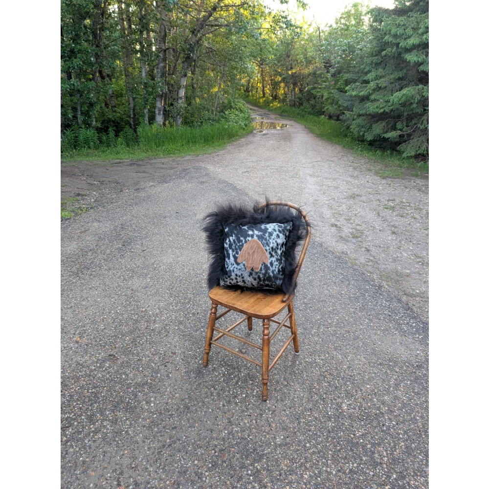 The yeti cushion icelandic sheepskin pillow with black and white cowhide paw print and fluffy black long wool trim