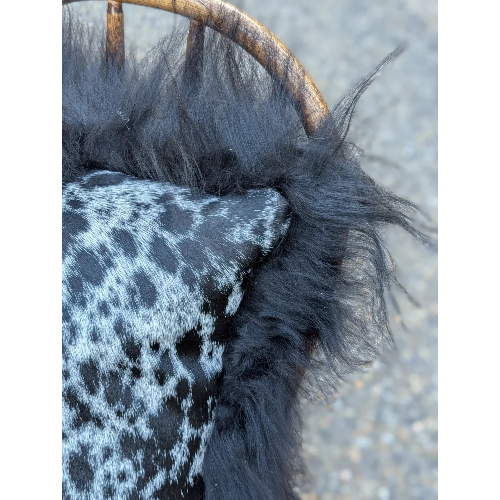 Black faux fur pillow with gray and black leopard print fabric in the yeti cushion featuring icelandic sheepskin long wool