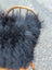 Black fluffy icelandic sheepskin throw with long wool draped over wooden chair from the yeti cushion cowhide natural black collection