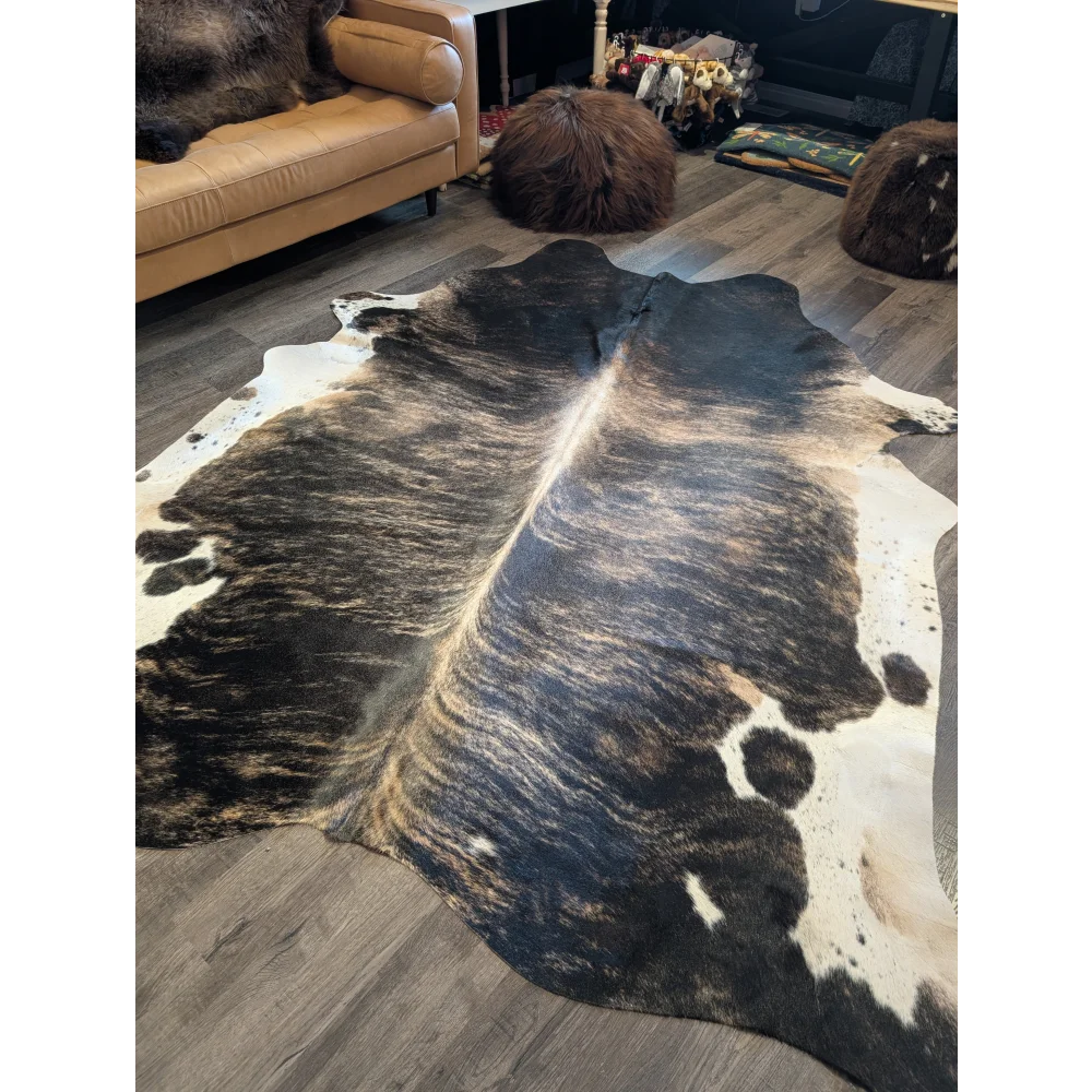 A beautiful large cowhide rug in natural black and white with a textured irregular pattern, extra large cowhide size