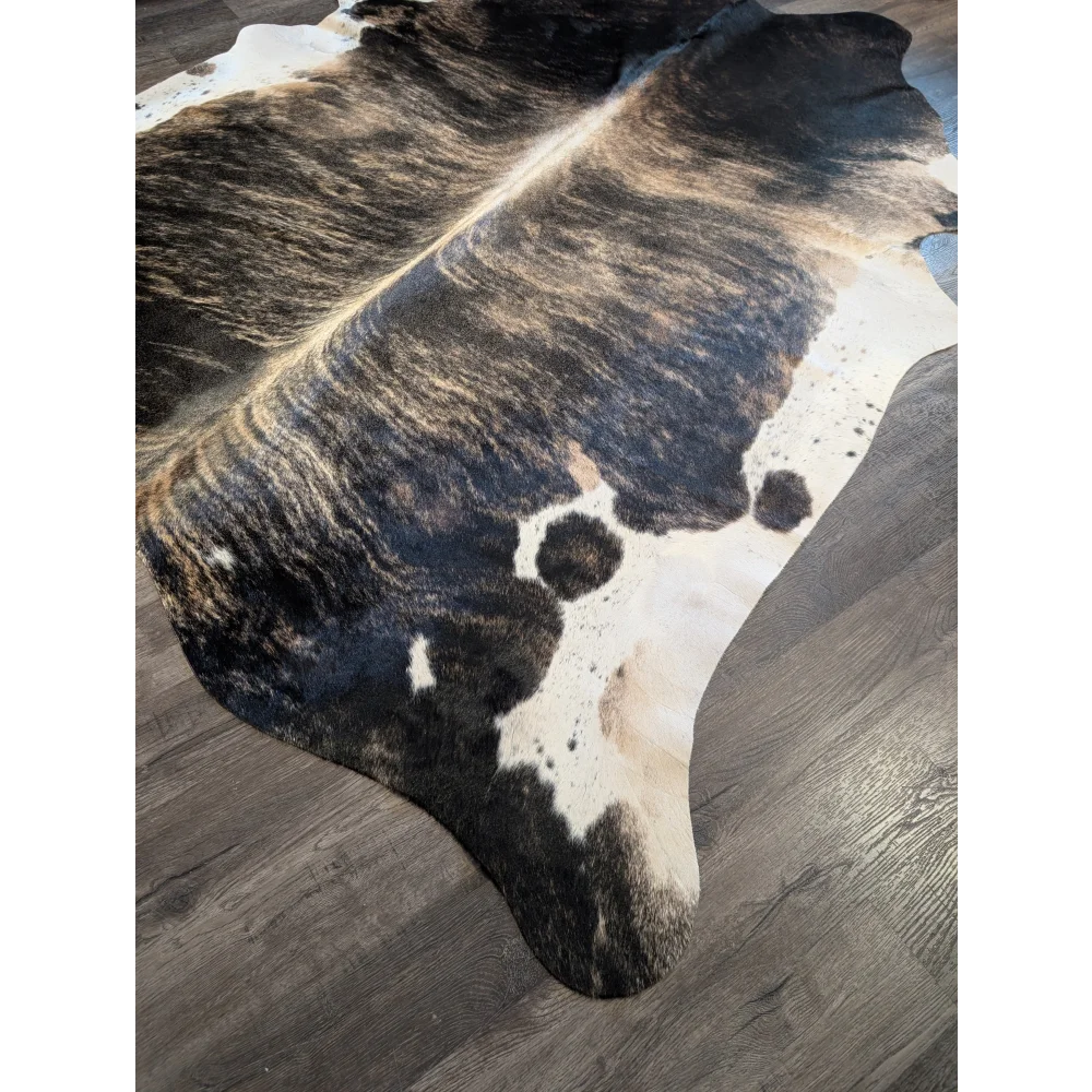 A beautiful extra large black and white cowhide rug with distinctive dark patches perfect for stylish decor