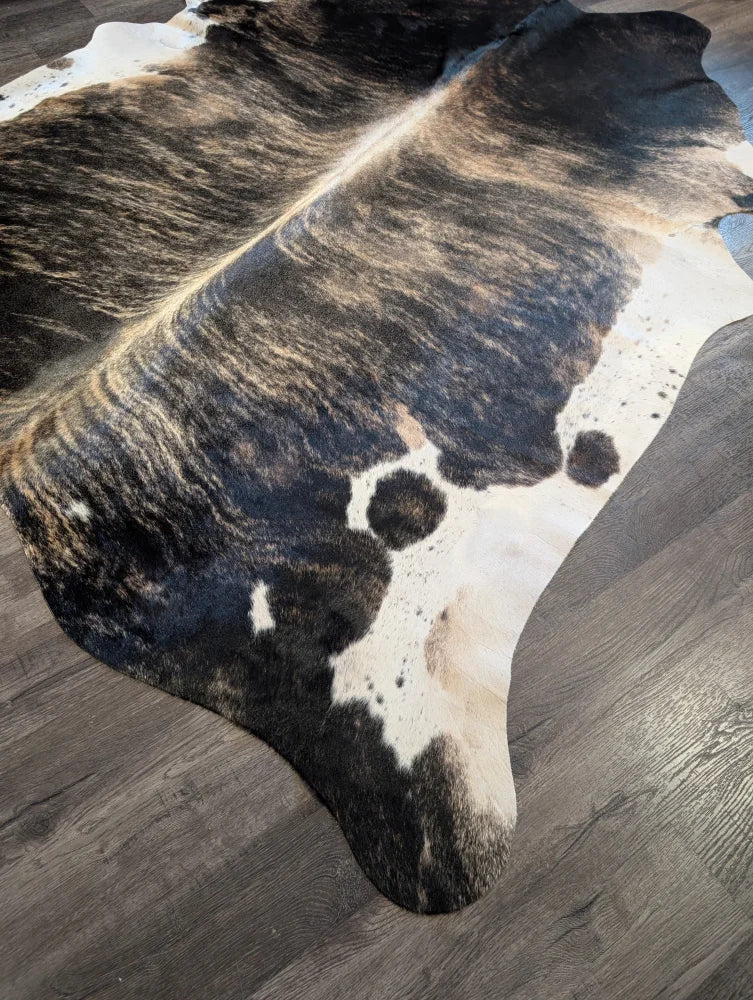 A beautiful extra large black and white cowhide rug with distinctive dark patches perfect for stylish decor