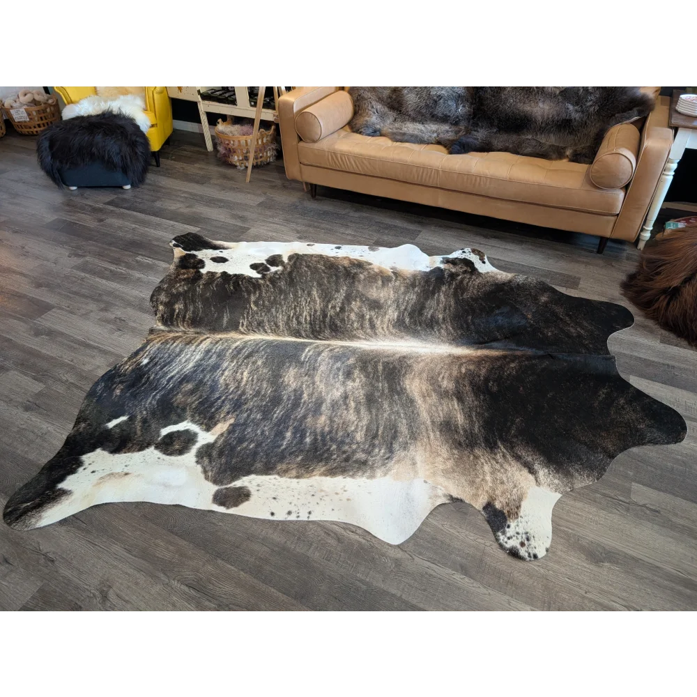 A beautiful extra large black and white cowhide rug with a textured irregular pattern perfect for stylish floors