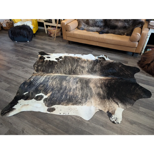 A beautiful extra large black and white cowhide rug with a textured irregular pattern perfect for stylish floors