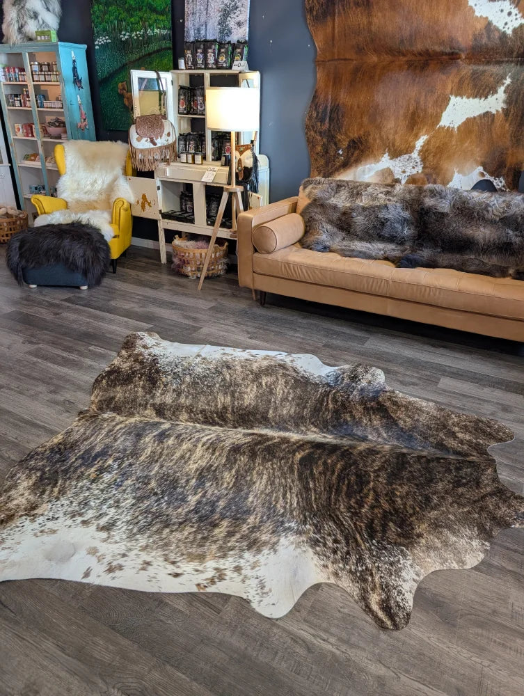 A beautiful extra large brown and white natural cowhide rug with a textured irregular pattern perfect for floors