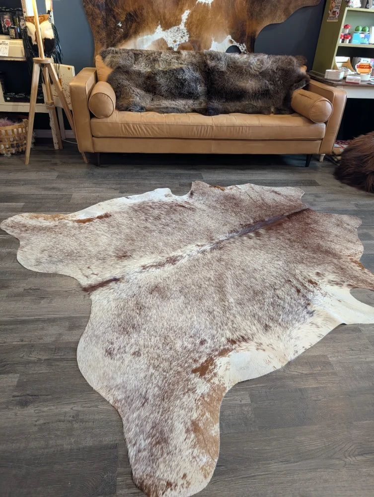 Gorgeous extra large cowhide rug in brown and white with natural fur texture perfect for beautiful rugs lovers