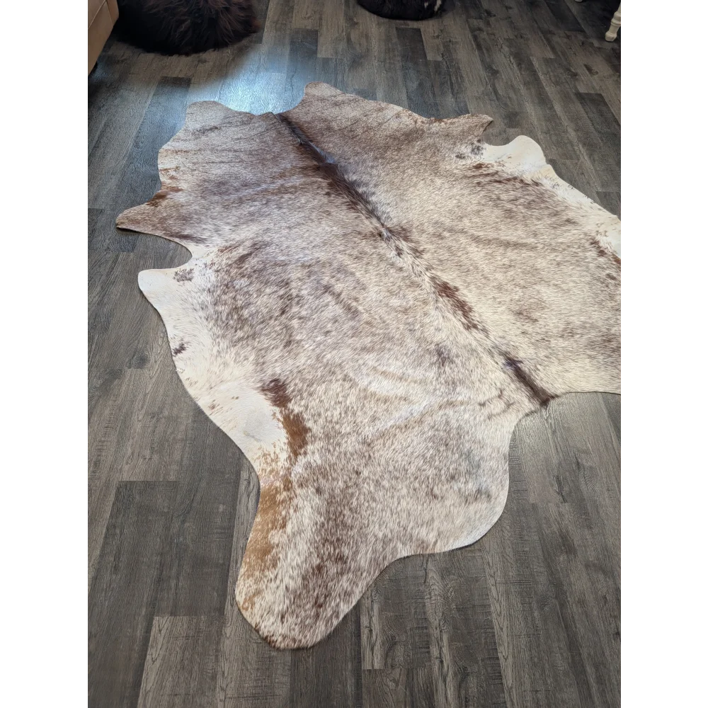 Extra large natural-toned large cowhide rug with mottled beige brown and white fur perfect for beautiful rugs collection