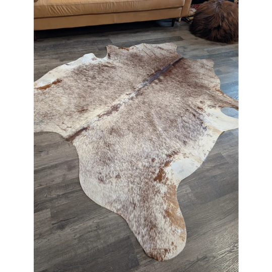 Extra large natural brown and white cowhide rug with textured fur surface perfect for beautiful rugs collection