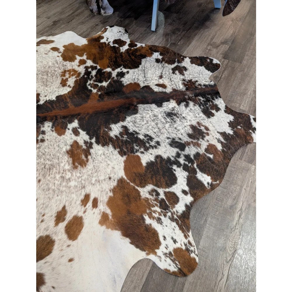 Extra large cowhide rug tricolour101 with brown white and black patches showcasing rustic charm and unique characteristics