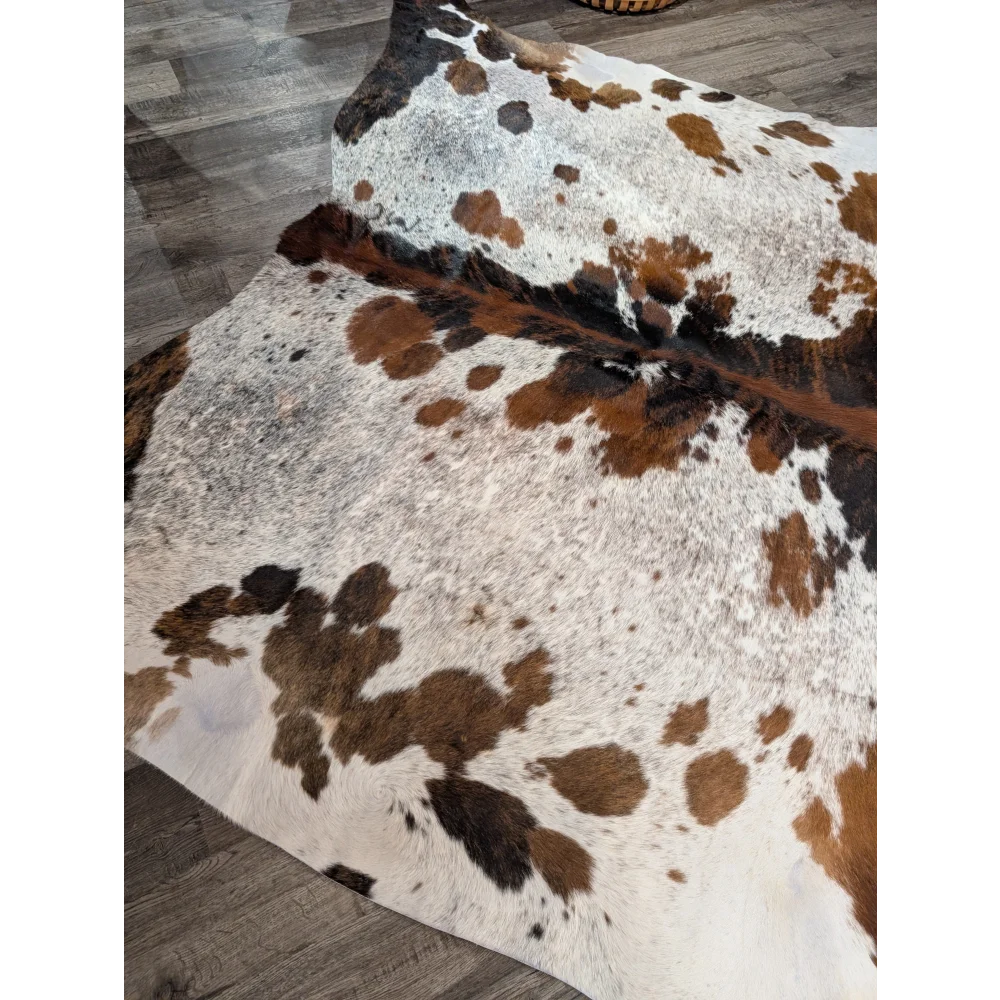 A gorgeous extra large cowhide rug tricolour 101 with a white base and rustic charm featuring unique characteristics