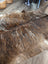 Brown and white extra large cowhide rug with natural textured fur pattern and unique characteristics for rustic charm