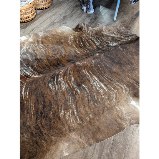 Brown and white extra large cowhide rug with natural textured fur pattern and unique characteristics for rustic charm