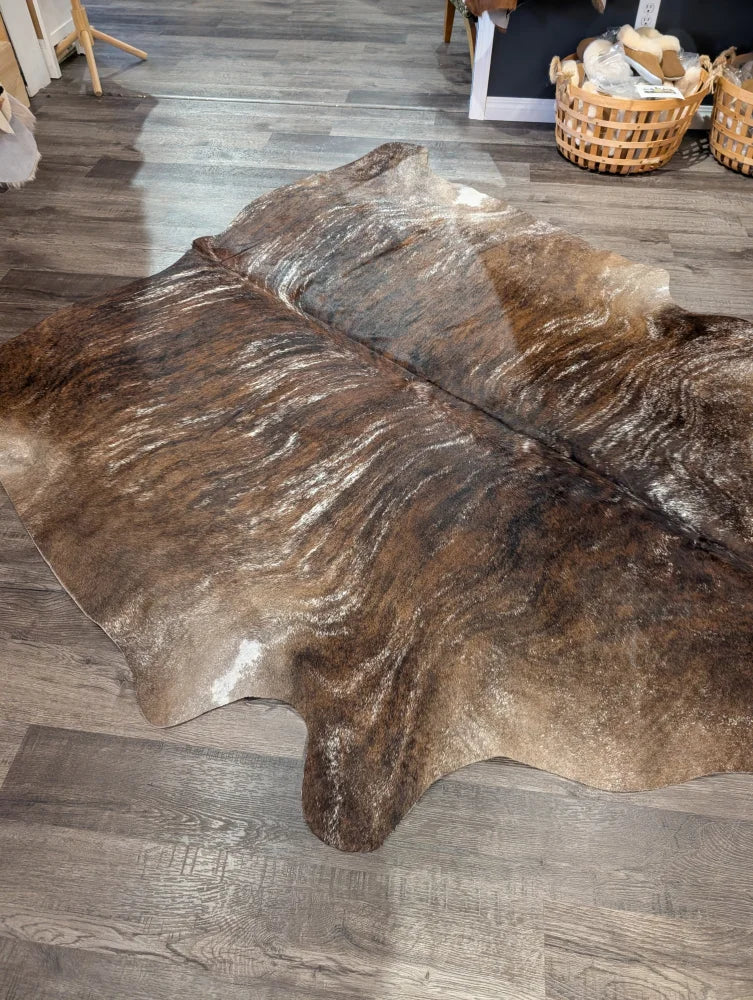 Brown and white extra large cowhide rug with natural irregular edges showcasing rustic charm and unique characteristics