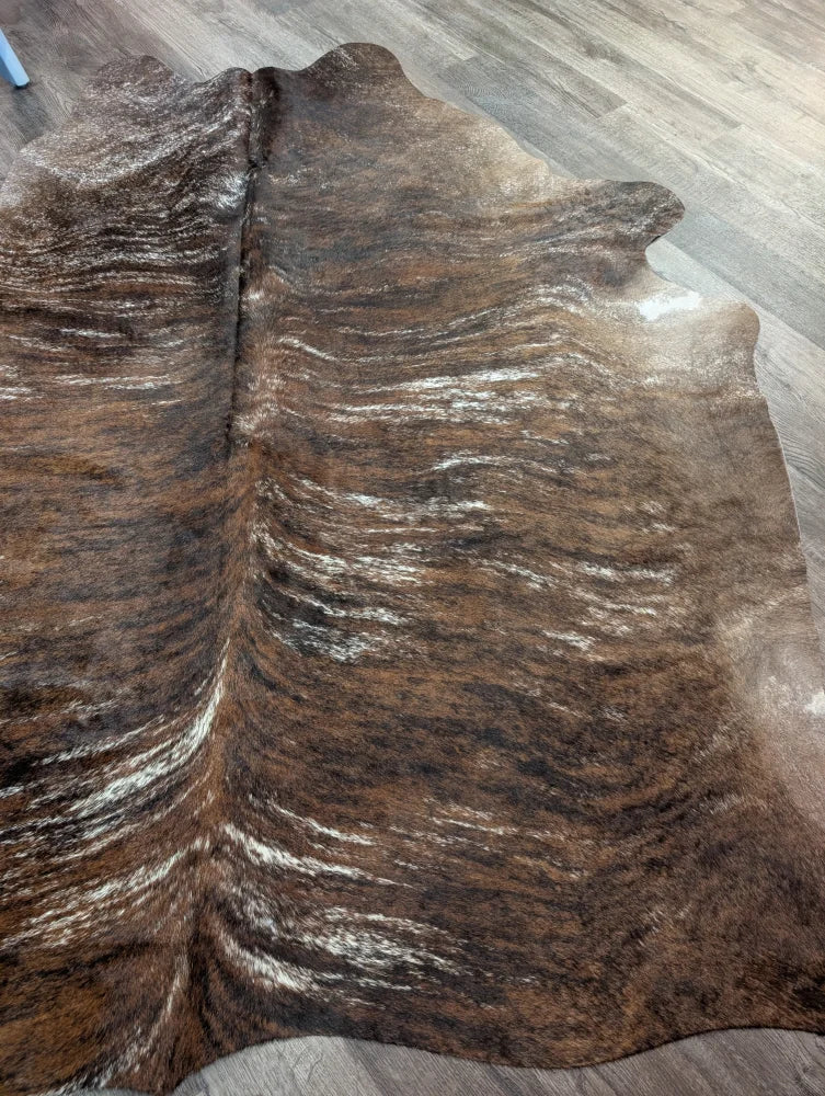 Brown and white extra large cowhide rug with rustic charm and unique characteristics featuring natural textured patterns