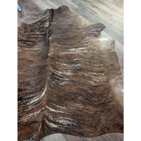 Brown and white extra large cowhide rug with rustic charm and unique characteristics featuring natural textured patterns