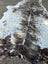Large tricolour#171 cowhide rug with black and white spotted pattern and subtle brown accents showing unique characteristics and rustic charm
