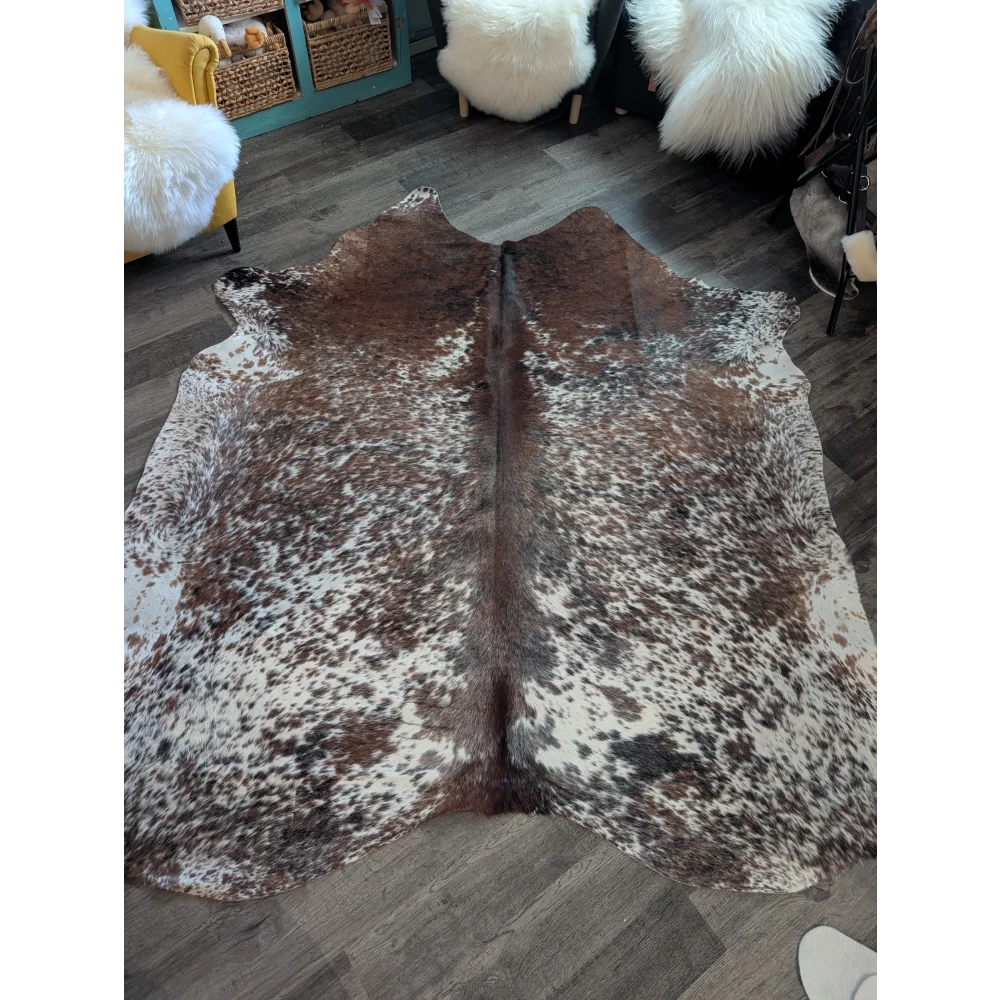 Brown and white spotted extra large cowhide rug with a natural textured surface perfect for beautiful rugs decor