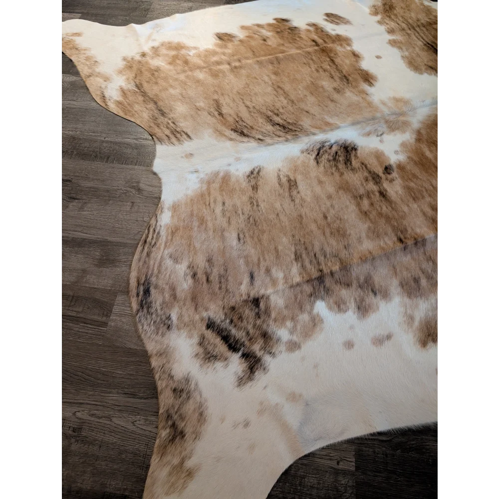 A gorgeous extra large cowhide rug in tri color white tan and brown spotted pattern perfect as a large cowhide decor