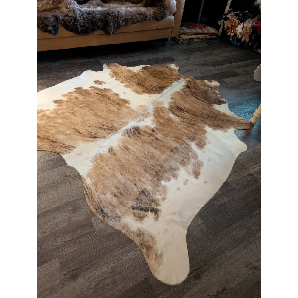 A natural brown and white extra large cowhide rug with a soft textured surface perfect as a large cowhide decor piece