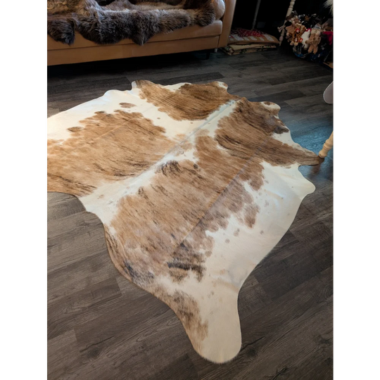 A natural brown and white extra large cowhide rug with a soft textured surface perfect as a large cowhide decor piece