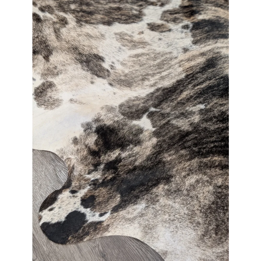 A gorgeous extra large cowhide rug with rustic charm featuring a unique black white and gray spotted pattern