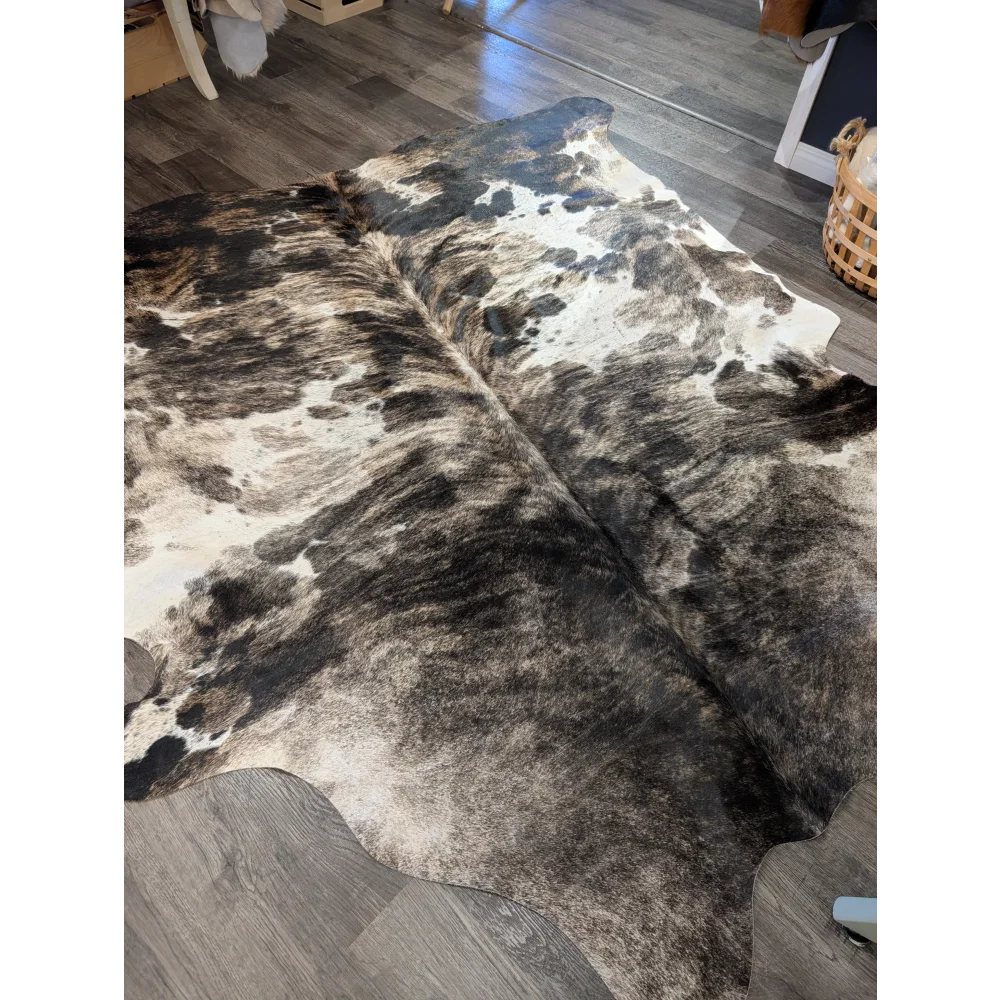 A gorgeous extra large cowhide rug tricolour 95 with a black and white spotted pattern showing unique characteristics and rustic charm