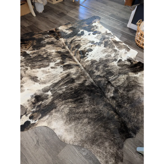 A gorgeous extra large cowhide rug tricolour 95 with a black and white spotted pattern showing unique characteristics and rustic charm
