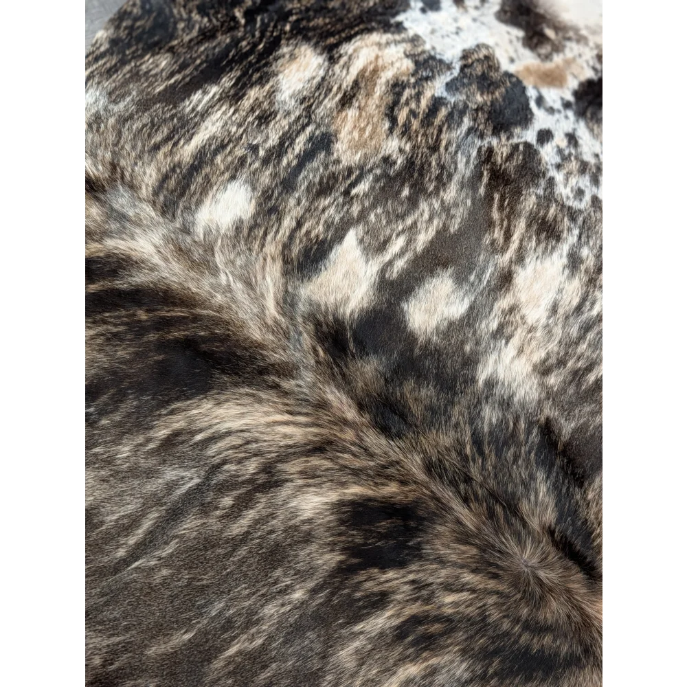 A plush extra large cowhide with natural black and white spotted pattern showing unique rustic charm