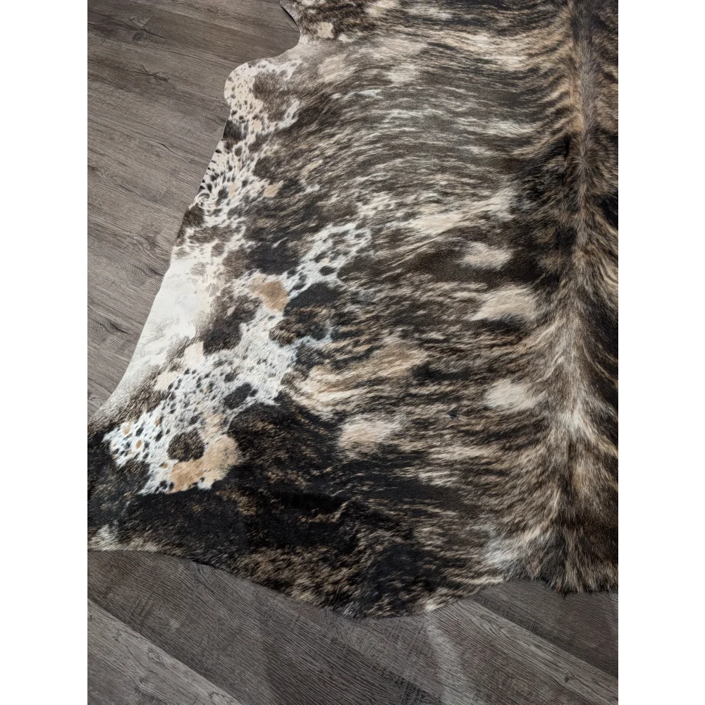 A gorgeous extra large cowhide rug with rustic charm featuring unique black white and tan mottled patches