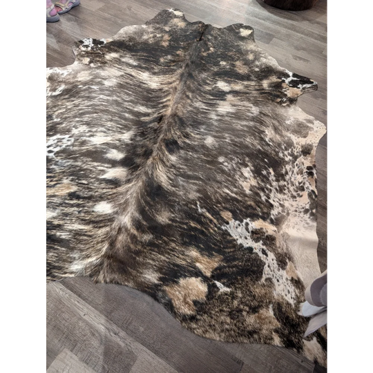 A natural extra large cowhide rug tricolour 99 with rustic charm and unique characteristics in black white and tan patches