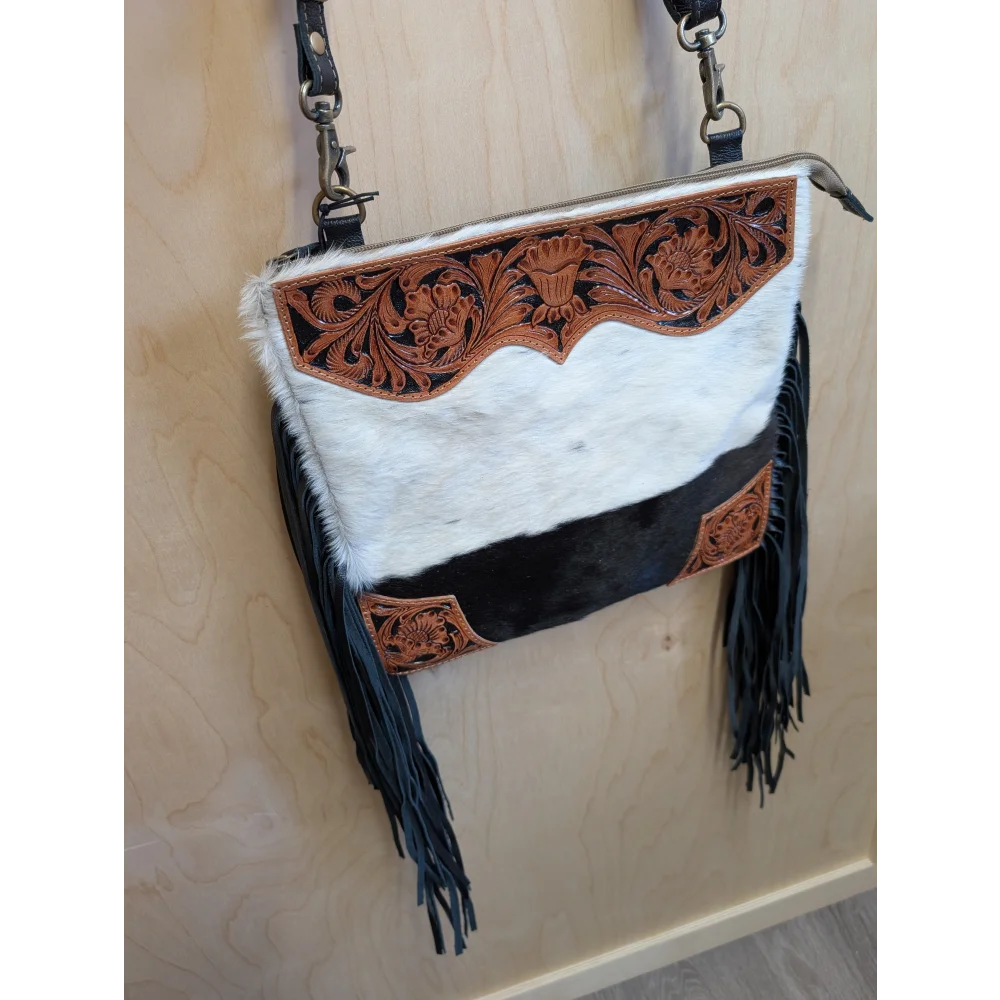 A stylish tumbleweed 2 crossbody bag with hand tooled brown leather floral embroidery smoky charcoal fur and zippered pocket