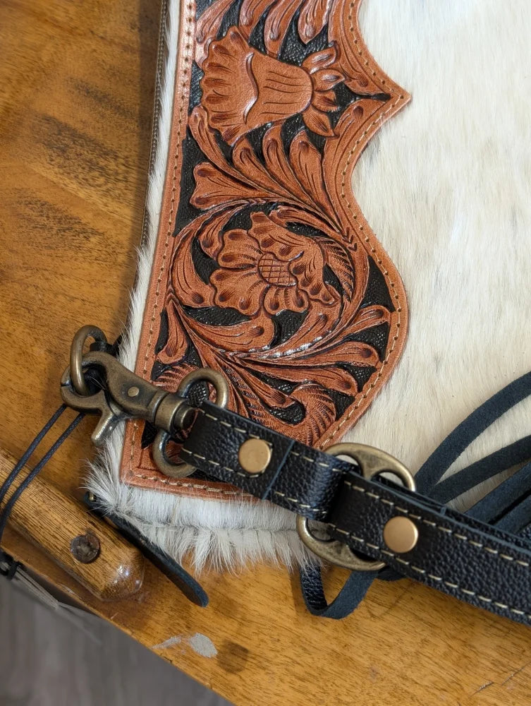 A tan hand tooled leather tumbleweed 2 tassel purse with black stitching brass hardware white fur trim and zippered pocket
