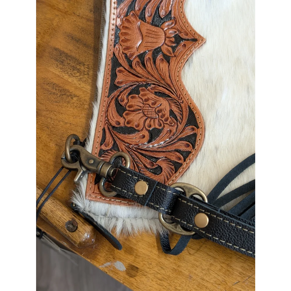 A tan hand tooled leather tumbleweed 2 tassel purse with black stitching brass hardware white fur trim and zippered pocket