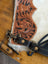 A tan hand tooled leather tumbleweed 2 tassel purse with black stitching brass hardware white fur trim and zippered pocket