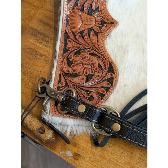 A tan hand tooled leather tumbleweed 2 tassel purse with black stitching brass hardware white fur trim and zippered pocket