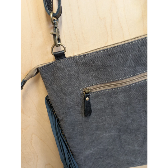 Gray denim crossbody bag tumbleweed 2 with black leather accents fringed detail and zippered pocket in smoky charcoal