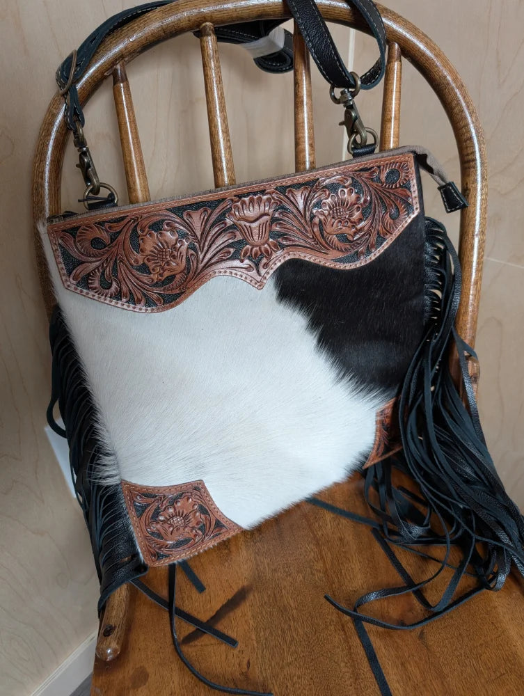 Tumbleweed 4 smoky charcoal black and white cowhide crossbody bag with hand tooled brown floral embroidery and zippered pocket