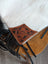 A tan hand tooled leather patch with black stitching on white cowhide for the tumbleweed 4 smoky charcoal tassel purse