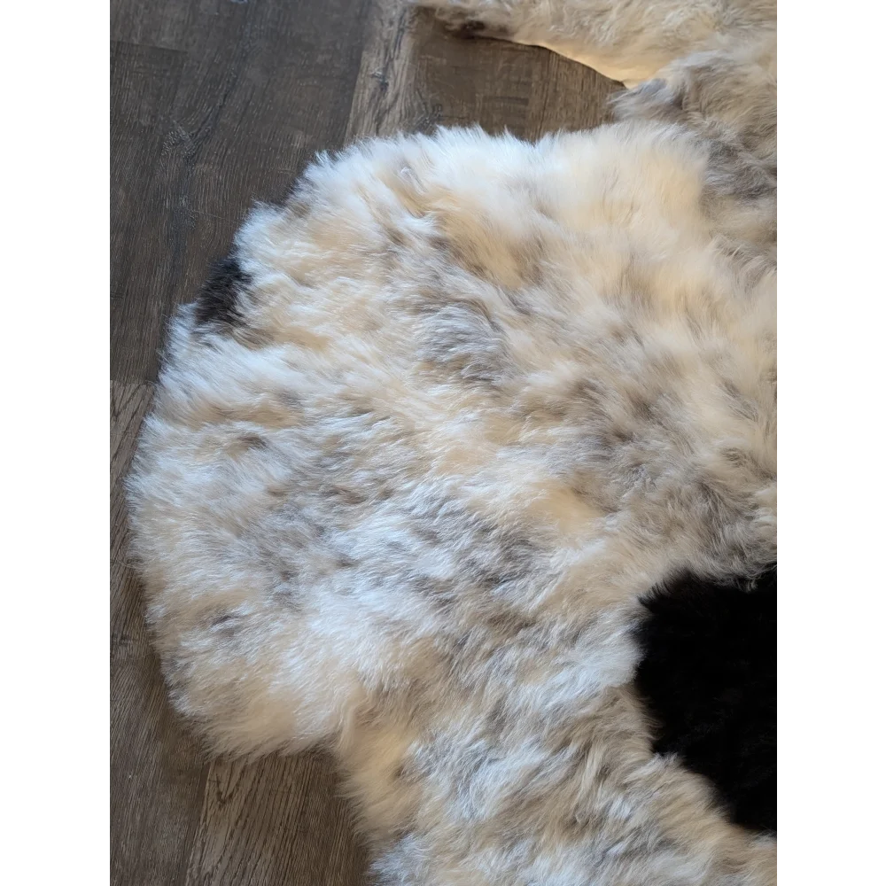 A plush icelandic sheepskin rug with short wool in cream gray and black spotted pattern spot 7 and 6