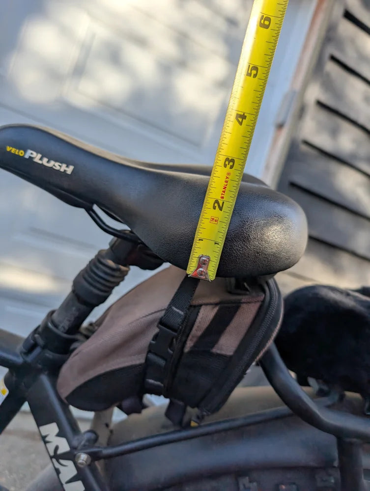 Black merino sheepskin bicycle seat with yellow tape for height adjustment