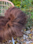 A plush brown wool icelandic sheepskin throw draped over a wicker chair perfect for cozy decor